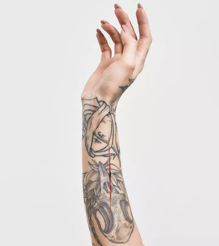A tattooed hand of a woman with a cut in the middle