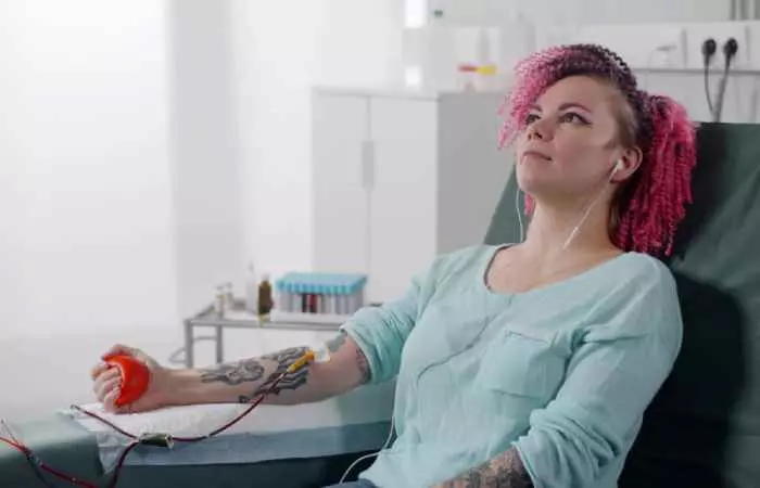 A tattooed person donating plasma