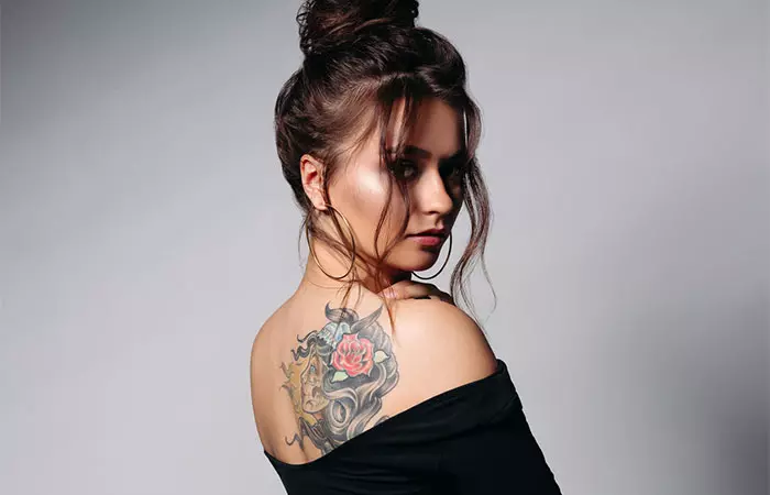 A woman with a healed, colorful tattoo on the back of her shoulder