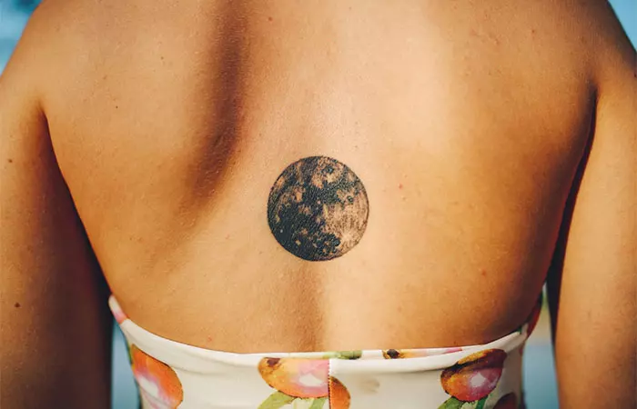 A woman with a palm sized moon tattoo on her back