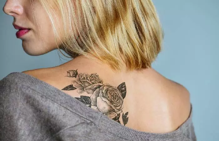 A woman with a rose tattoo on her back.