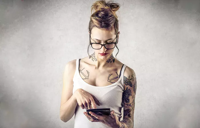 Woman with tattoos calculating the price of glow-in-the-dark tattoos