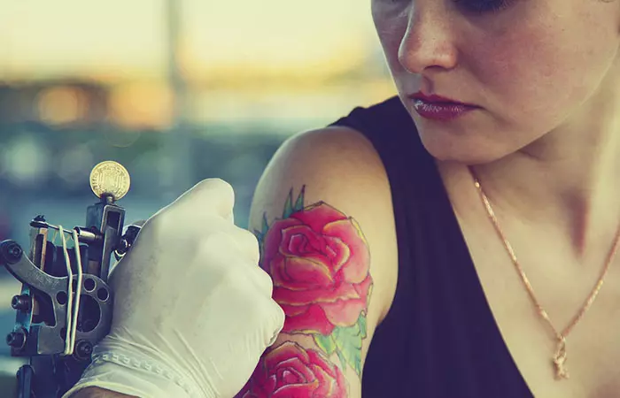 Woman getting a glow-in-the-dark tattoo on her arm