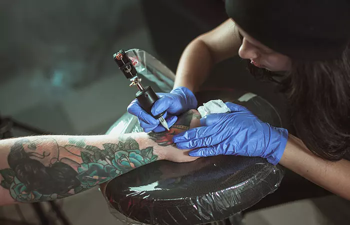An experienced artist doing army tattoo touch-up