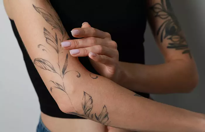 A woman applying ointment to her tattoos