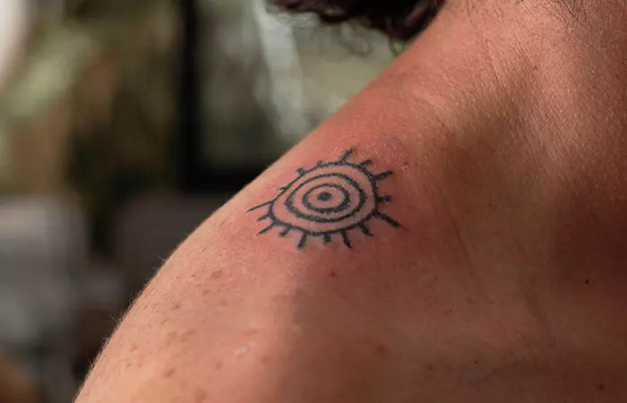 Minimalist spiral tattoo on a shoulder
