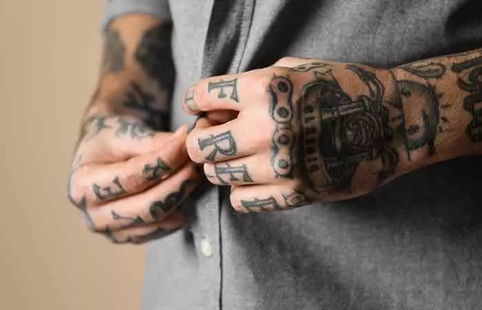 man with American traditional tattoos inked on both the hands
