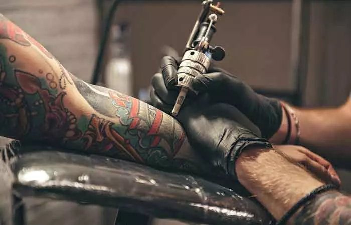 A close-up of a tattoo artist inking a neo-traditional tattoo