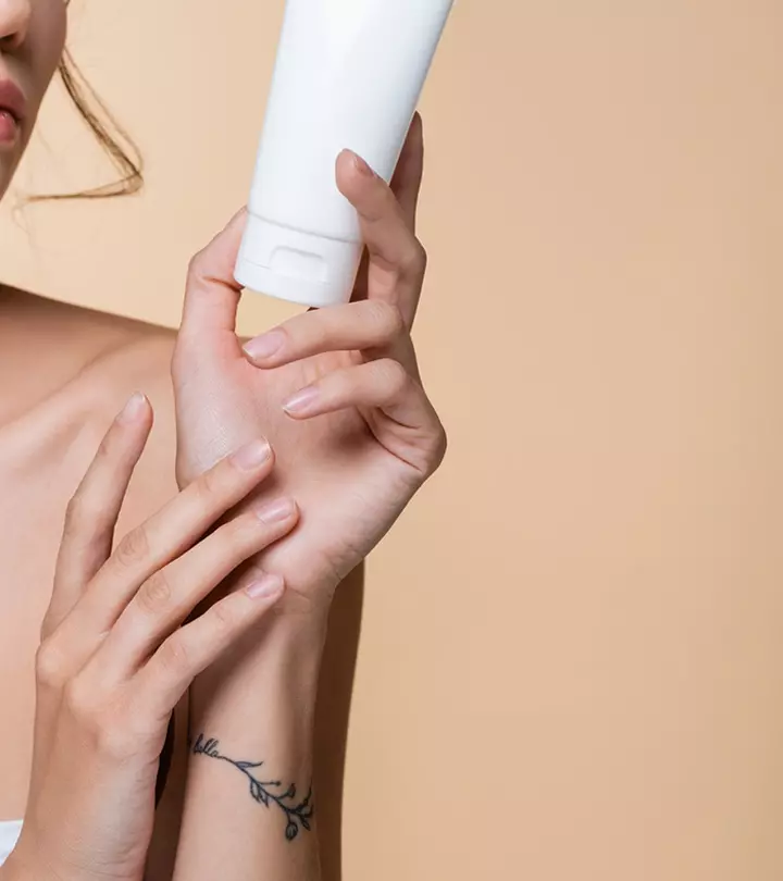 Woman with a tattoo holding a tattoo aftercare product
