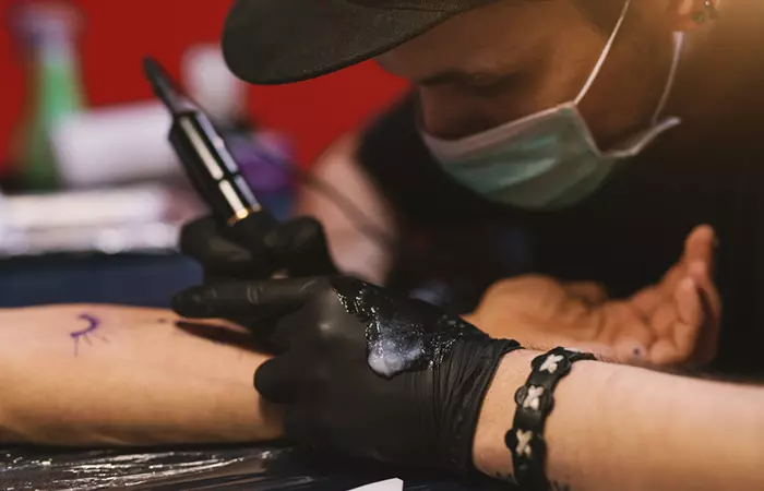 Tattoo artist engrossed in tattooing