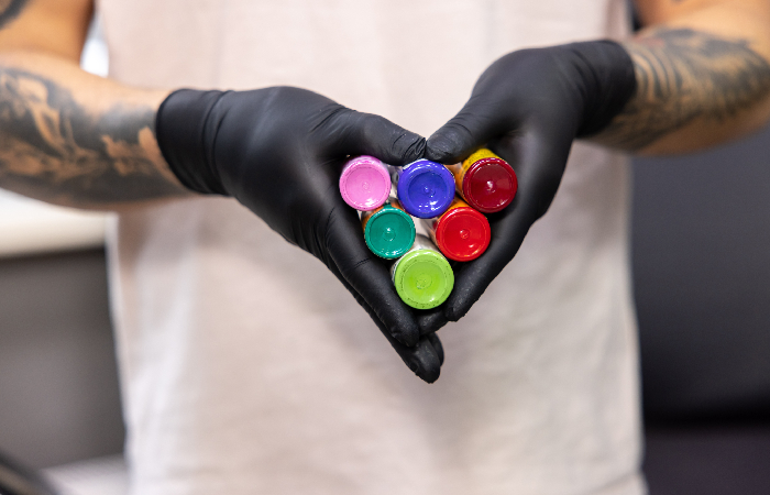 Tattoo artist holding tattoo ink bottles