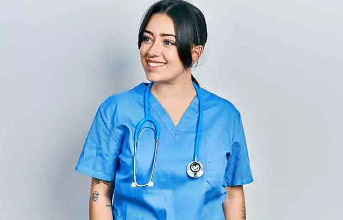 A surgeon with forearm tattoos and a stethoscope around her neck.