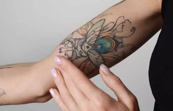 Woman applying vegan cream on tattoo