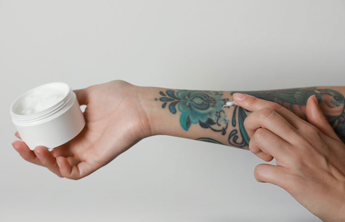 Women applying cream to her tattoo