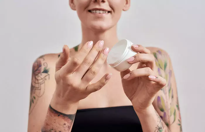  Women slathering moisturizer on her tattoo