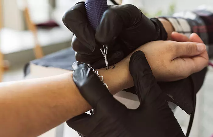 A woman getting a wrist tattoo