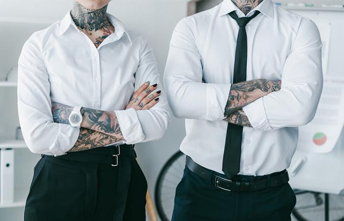 Young lawyers with tattoos standing with crossed arms