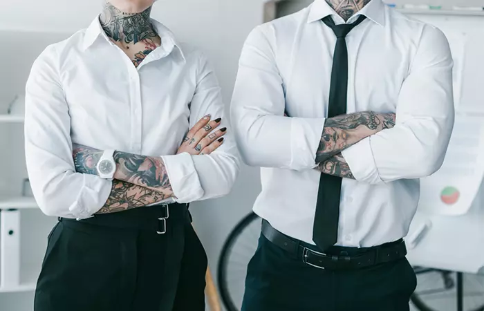 Young lawyers with tattoos standing with crossed arms