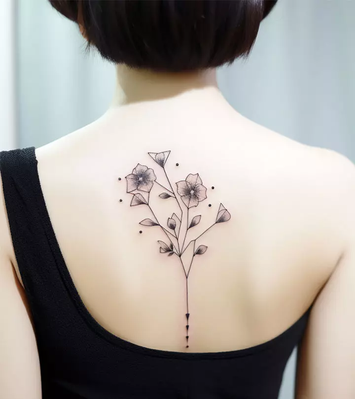 A young woman displaying a fine line tattoo on her back