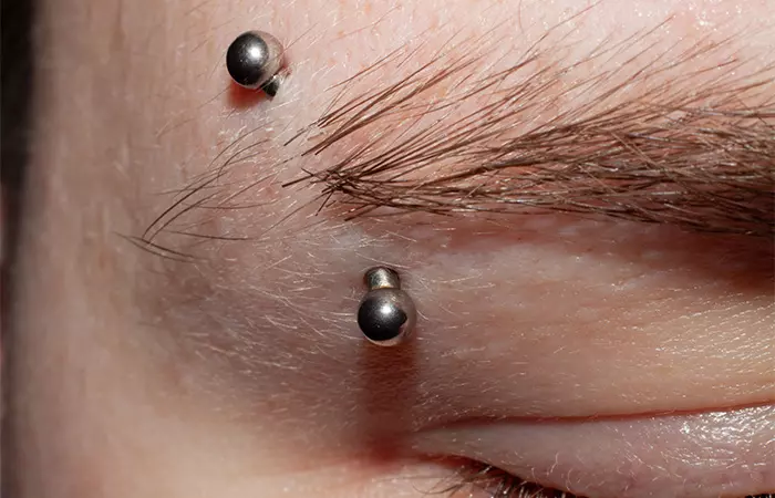 A closeup of an eyebrow surface piercing