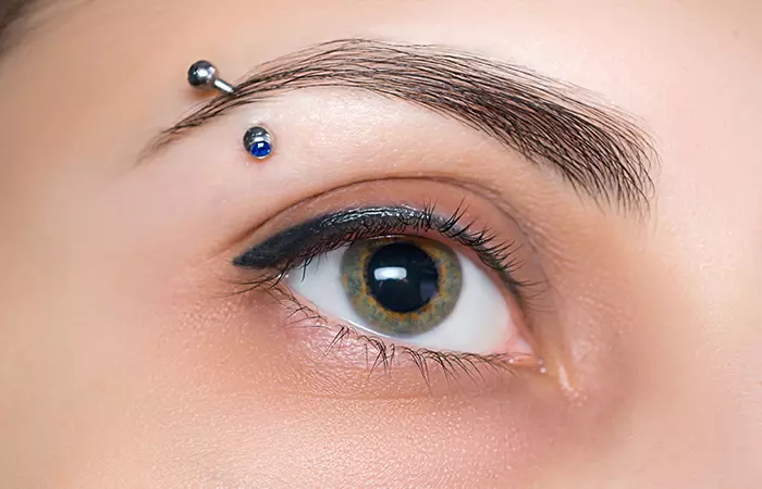 A curved barbell eyebrow piercing