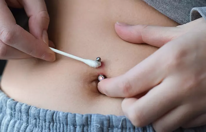 A person cleaning their belly piercing