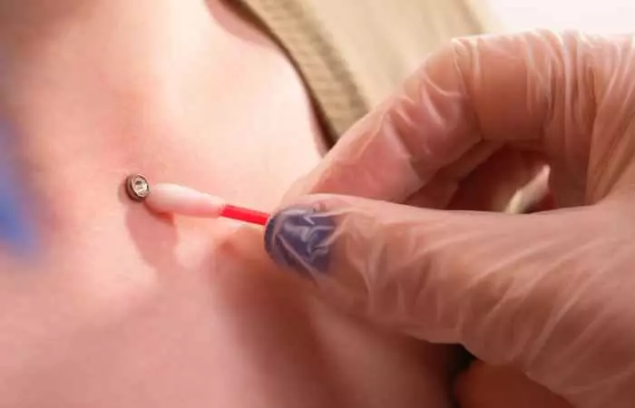 A piercing professional cleaning a non removable piercing jewelry