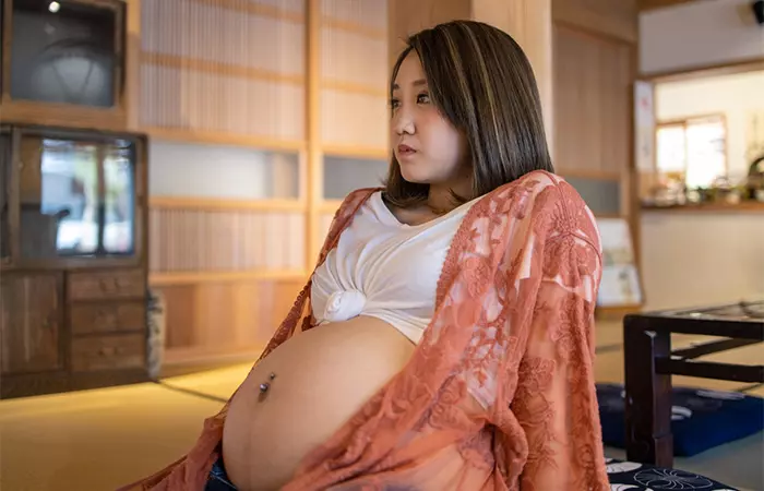 A pregnant woman with a belly button piercing