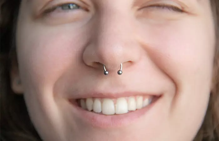 A smiling woman with a septum piercing