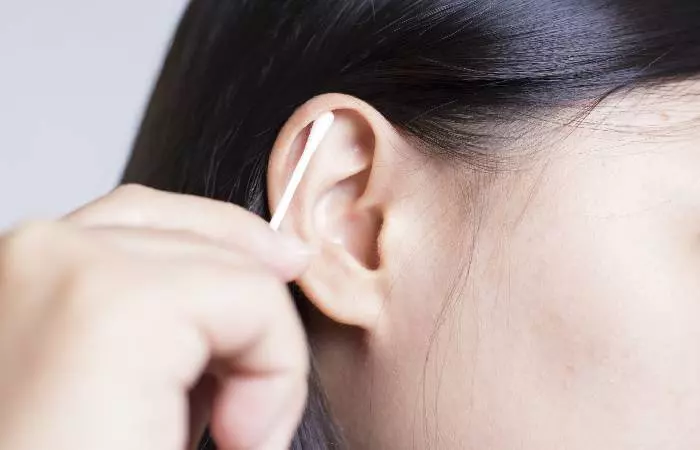 A woman changing her ear jewelry