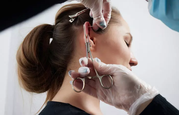 A woman getting a flat piercing