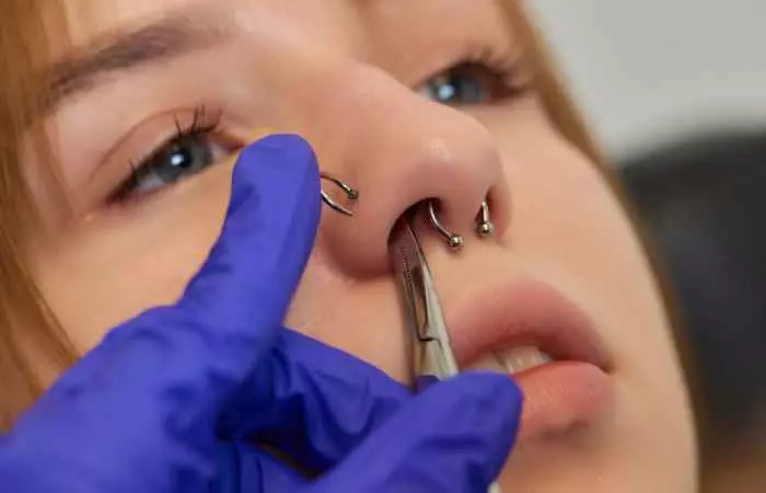 A woman getting a nose piercing