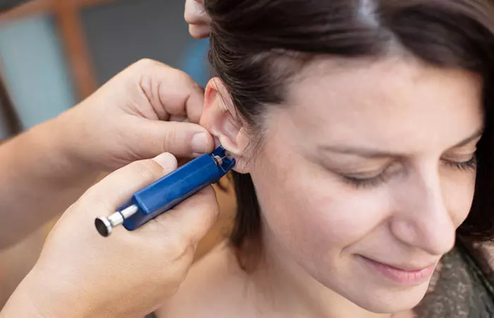 A woman getting her ears pierced