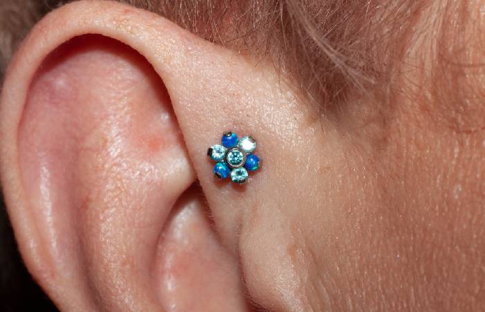 A woman sports a forward helix piercing