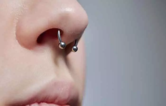 A woman sports a silver ring in her septum piercing