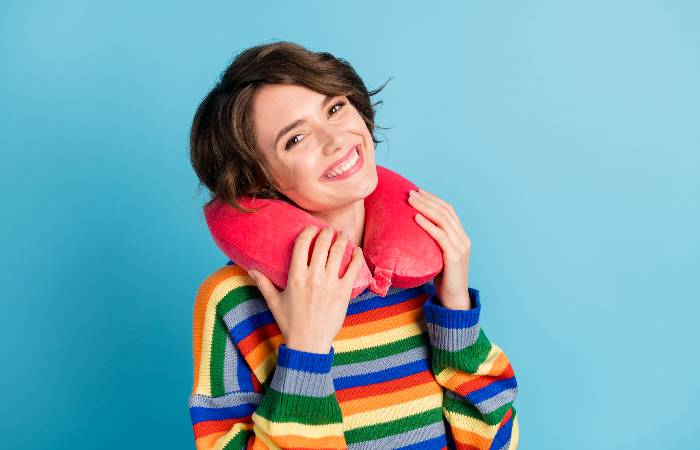 A woman uses a travel pillow to keep her ear piercing safe