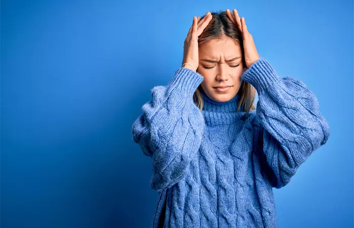 A woman wincing in pain due to experiencing severe migraine