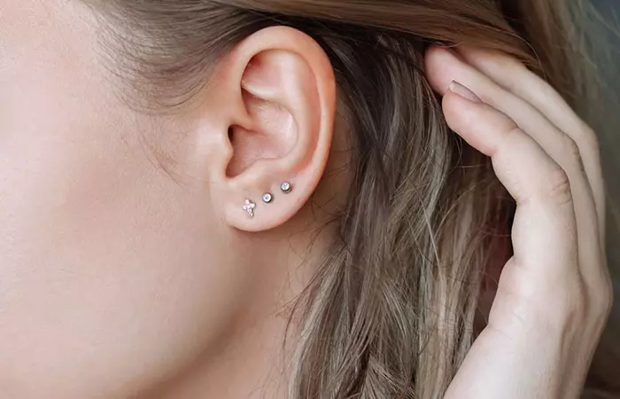 A woman shows off her minimalistic curated ear piercings