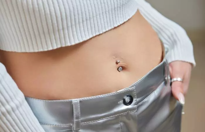 A close-up image of a woman with a double navel piercing