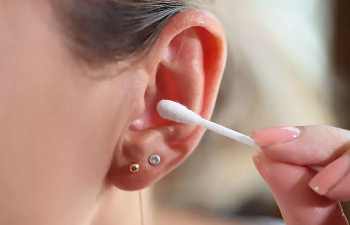 A woman cleaning her pierced ear