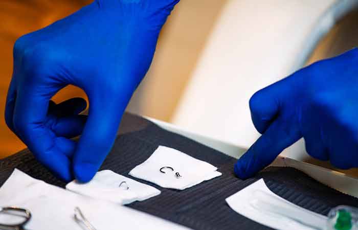 A man opening sterile equipment for piercing