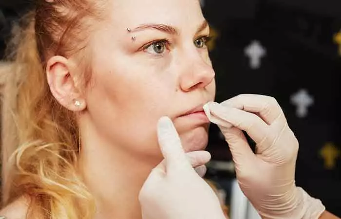 Woman cleaning her lip piercing
