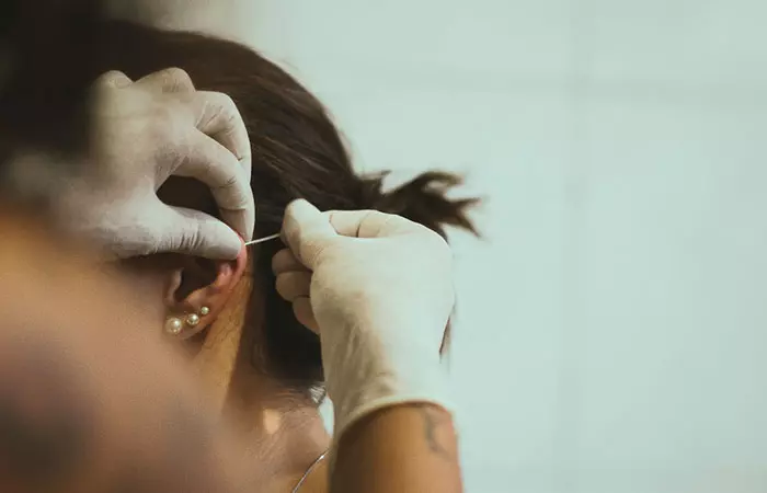 A woman getting curated ear piercings at a studio 