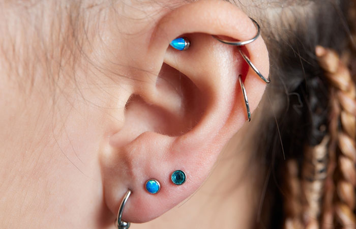 A woman with small hoops and jeweled earrings