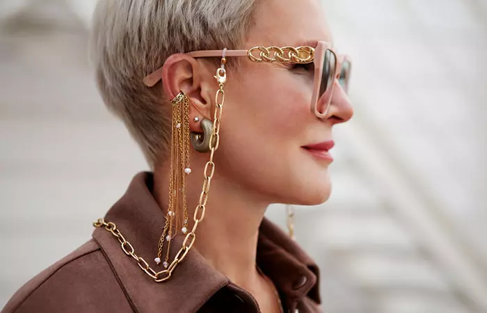 A woman wearing ear cuffs that match with her outfit