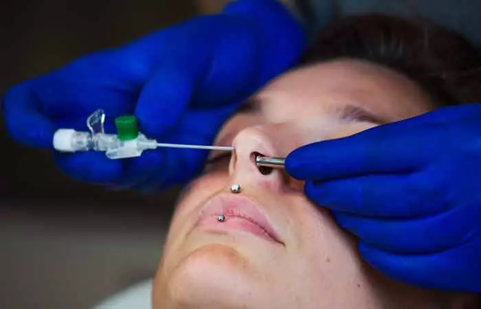 A woman getting an Austin bar nose piercing