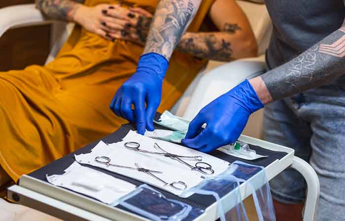 A professional arranging their sterilized tools for piercing