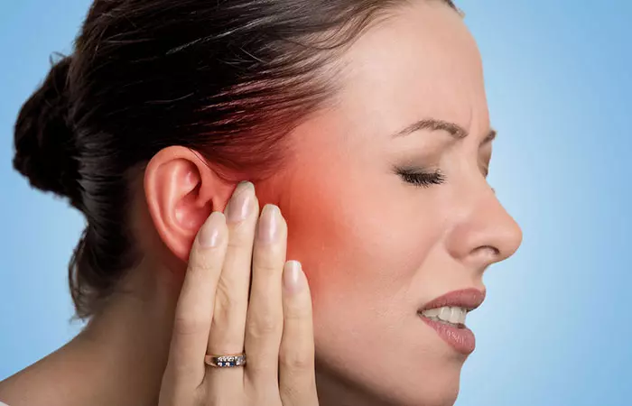 Woman suffering from ear redness and pain