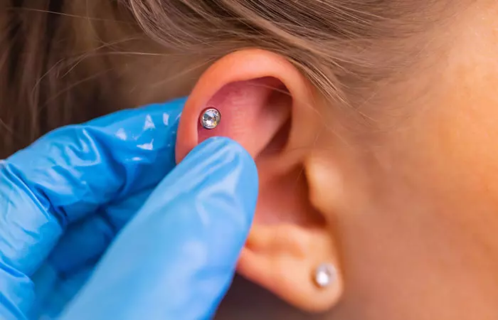 A woman experiences redness in her ear after getting a fresh piercing