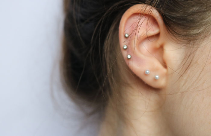 Two cartilage studs featuring gems at the upper ear area